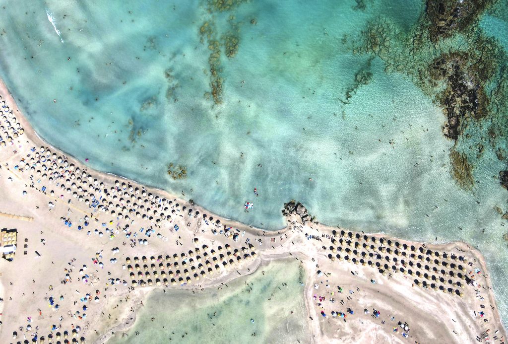 Vue aérienne du banc de sable d’Elafonisi, avec ses parasols et son lagon peu profond